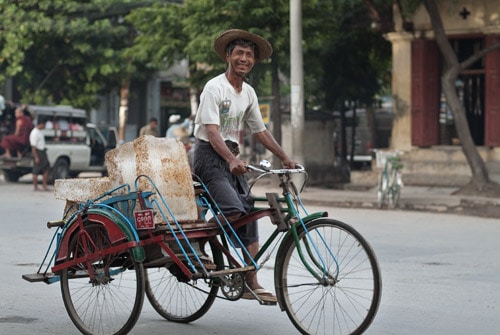 Alegre conductor cargando bloques de hielo en Mandalay