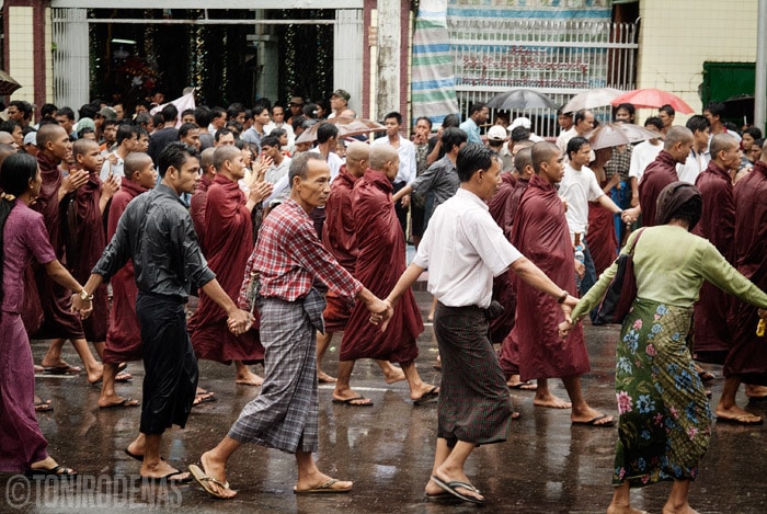 Birmanos con las manos unidas protegiendo a los monjes