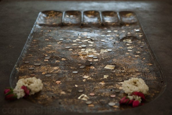 Detalle de la huella de Buda con monedas y pan de oro