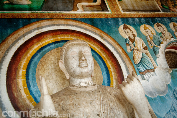 Una imagen de Buda en un pequeño templo al lado de la stupa